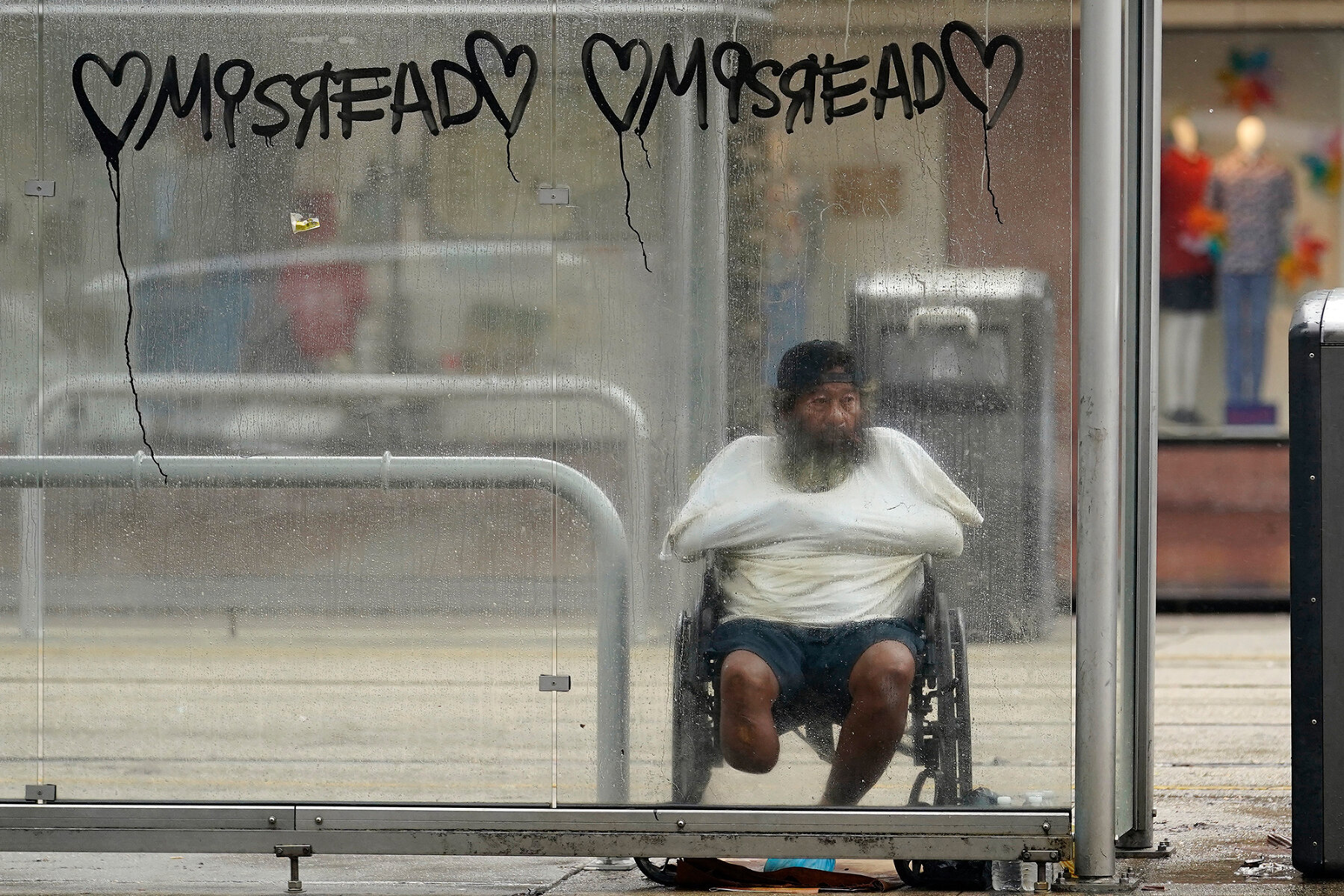 <p>Мужчина в инвалидной коляске прячется от урагана на автобусной остановке в Новом Орлеане, 29 августа 2021 года</p>