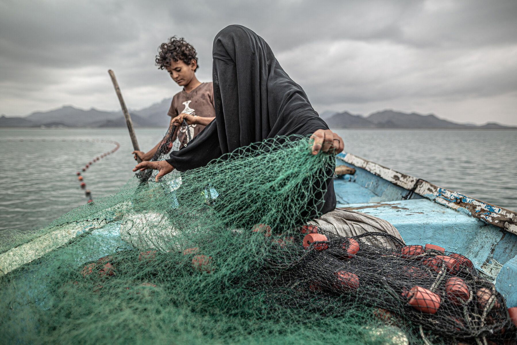 Yemen: Hunger, Another War Wound. <p>Номинация &laquo;Лучший снимок&raquo; в категории &laquo;Проблемы современности&raquo;. Женщина с сыном разворачивают рыболовную сеть в одном из заливов на побережье Йемена</p>