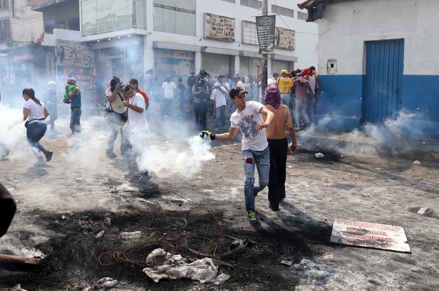<p>Протестующие во время столкновений с сотрудниками правоохранительных органов. Венесуэльские военные применяли слезоточивый газ.</p>