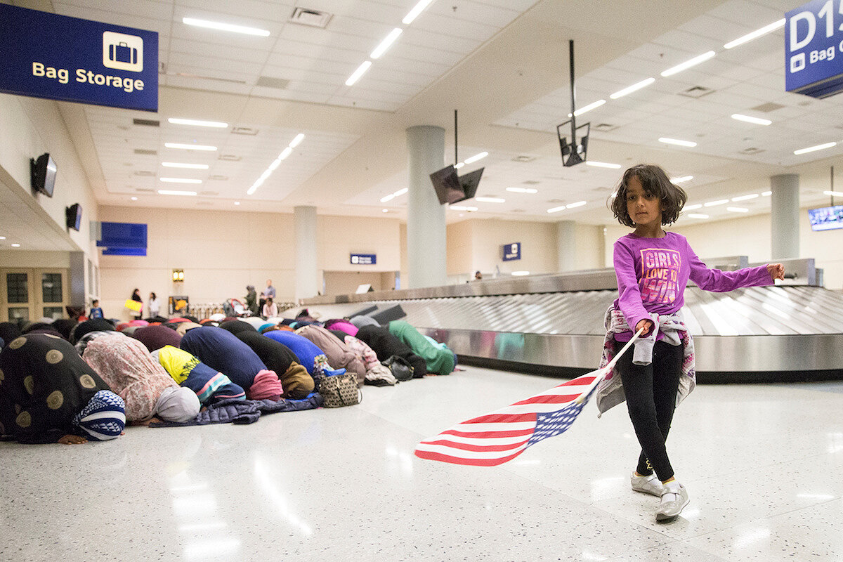 <p><strong>29 января. Даллас, США</strong></p>

<p>Девочка танцует с американским флагом в аэропорту рядом с женщинами, которые молятся, протестуя против <a href="https://tvrain.ru/articles/migranty_trampa-426503/" target="_blank">запрета</a>&nbsp;Дональда Трампа на въезд в США.</p>