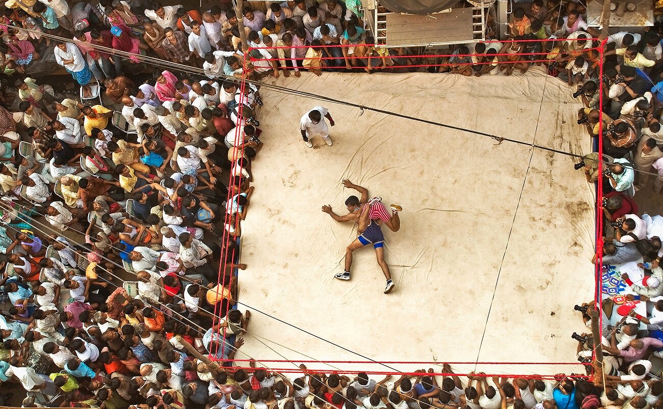 Enjoying Wrestling. <p>Поединок по борьбе проходит на закрытом на выходные рынке, Калькутта, Индия</p>