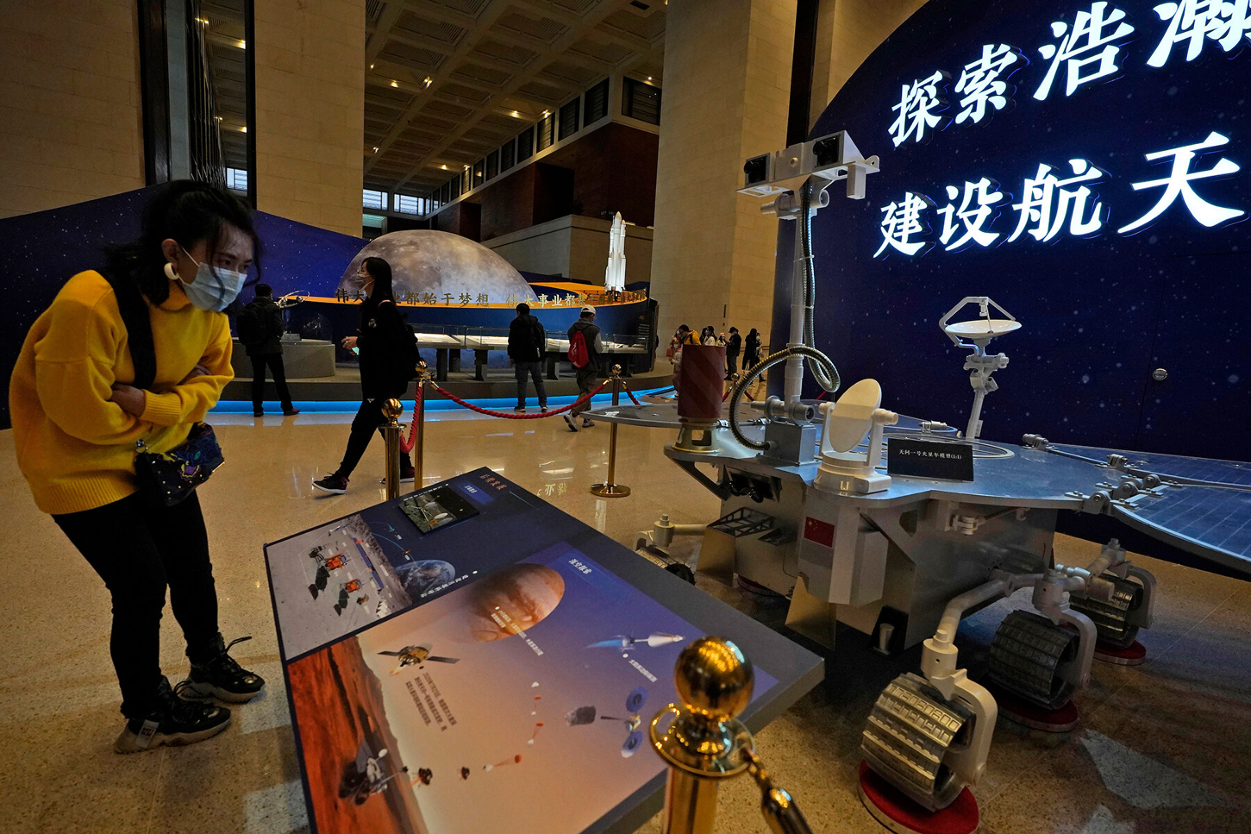 Китай. <p><strong>На фотографии</strong> &mdash; посетительница выставки в Пекине рассматривает макет-реплику китайского ровера &laquo;Тяньвэнь-1&raquo;. Китай, как и США, в данный момент реализует миссию по исследованию Марса. После успешного пуска 22 июля 2020 года миссия достигла орбиты Марса в феврале 2021 года и уже присылает фотографии поверхности планеты,&nbsp;а летом, после выбора места посадки, на Марс опустится автономный марсоход.</p>