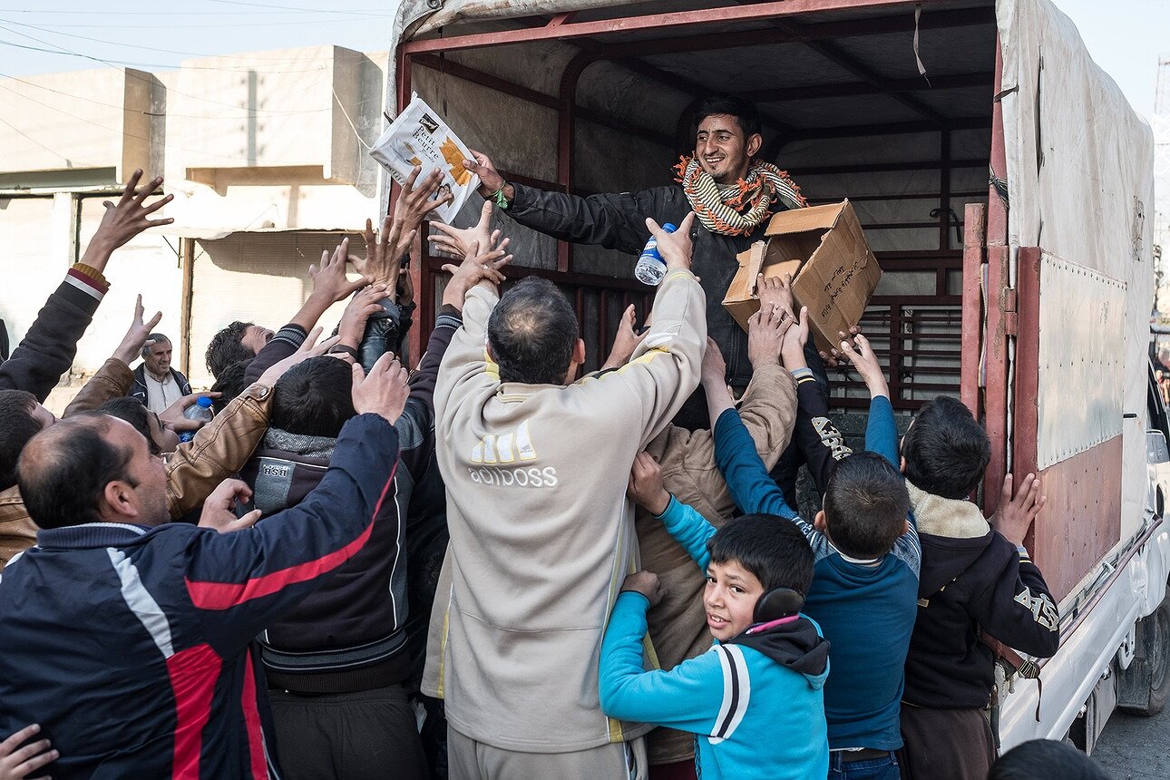 <p>Член иракской контртеррористической группы раздает продовольственную помощь мирному населению после освобождения района Аль-Кудс на востоке Мосула.</p>