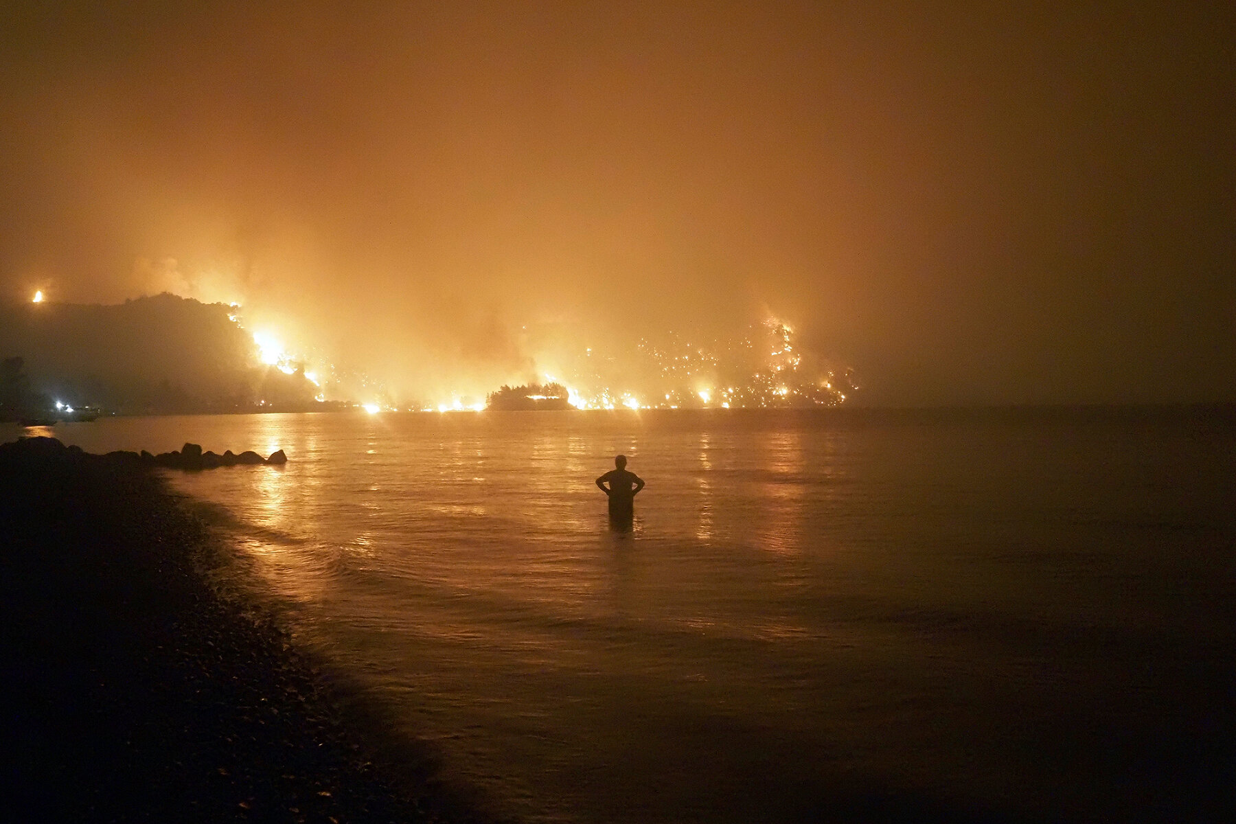 <p>Местный житель смотрит на лесной <a href="https://tvrain.ru/teleshow/here_and_now/greece_fire-535517/" target="_blank">пожар</a> на острове Эвбея, Греция, 6 августа 2021 года. Лето 2021 года запомнилось большим количеством лесных пожаров по всему миру, от <a href="https://tvrain.ru/news/ploschad_lesnyh_pozharov_v_rossii_v_2021_godu_dostigla_maksimuma_s_nachala_veka-538371/" target="_blank">Якутии</a>&nbsp;до <a href="https://tvrain.ru/teleshow/notes/klimat_na_steroidah_pochemu_potopy_i_pozhary_proishodjat_vse_chasche_i_pri_chem_tut_globalnoe_poteplenie-534798/" target="_blank">Калифорнии</a>. Эксперты ООН считают, что глобальное потепление имеет антропогенный характер, а среди его последствий будут не только пожары, но и наводнения.</p>
