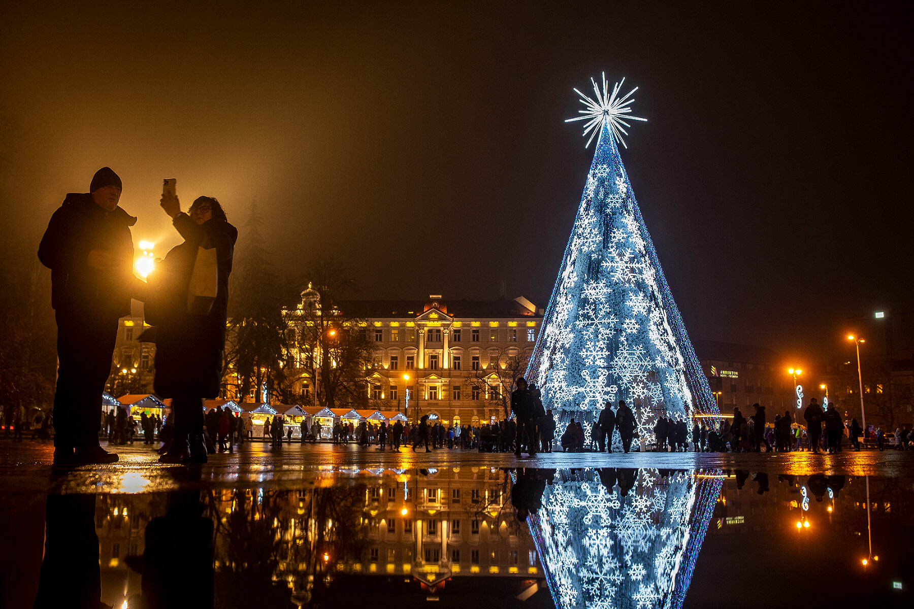 <p>Прохожая делает селфи с рождественской елкой на Кафедральной площади в Вильнюсе, 18 декабря 2021 года</p>