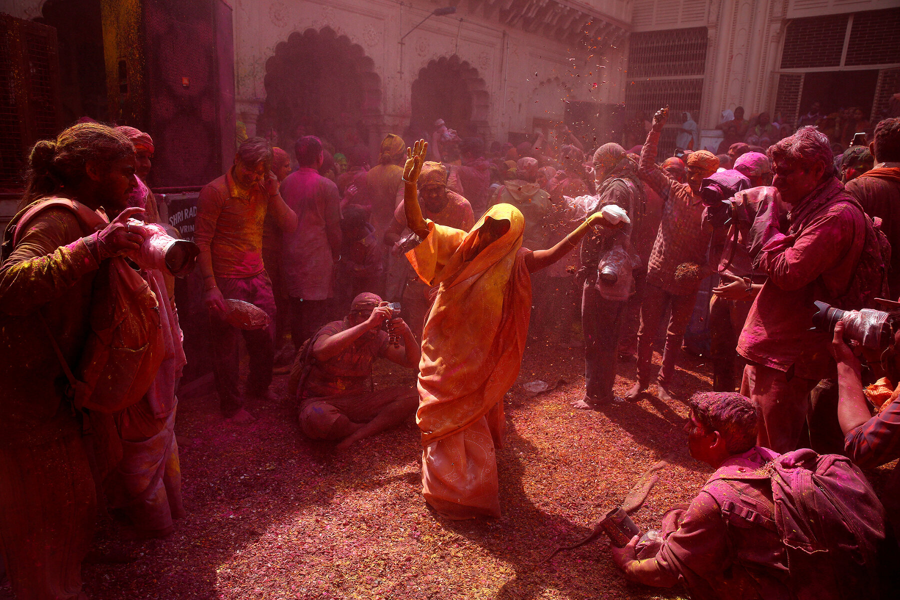 <p>Местные жители и индийские вдовы бросают лепестки цветов и цветной порошок&nbsp;во время празднования Холи в храме Гопинатх во Вриндаване.</p>