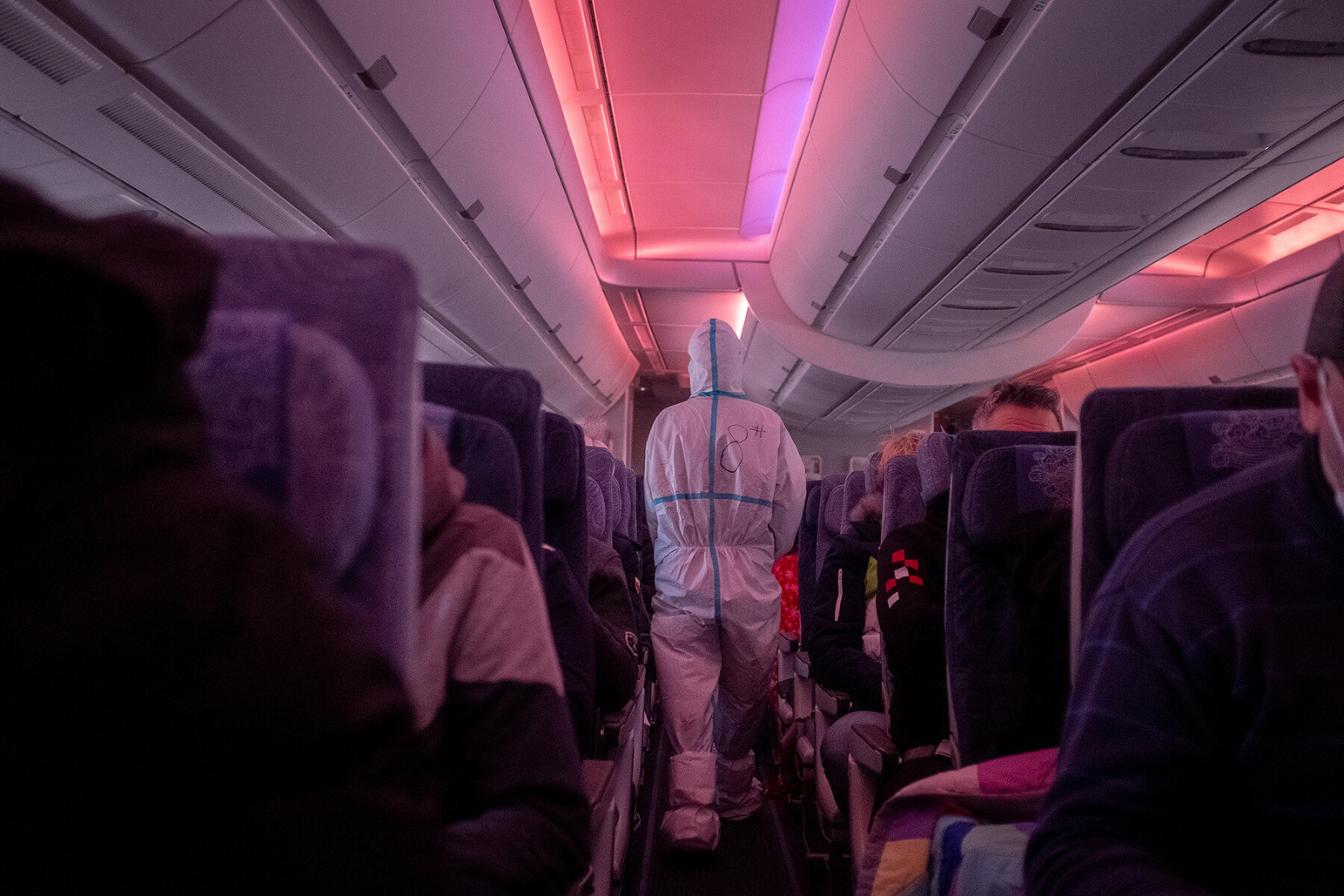 <p>Стюард в защитном костюме в самолете, на котором спортсмены и журналисты летят в Пекин из Италии, 1 февраля 2022 года.</p>