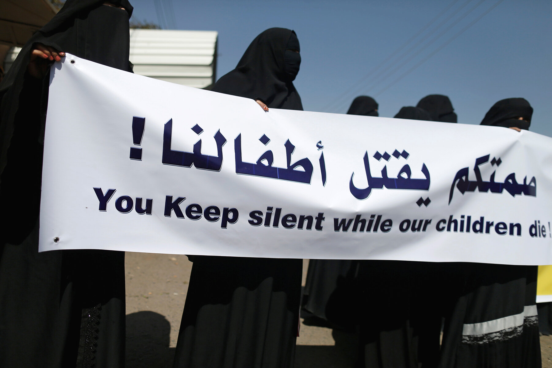<p>Женщины держат плакат, на котором написано «Вы сохраняете молчание, пока наши дети умирают» во время акции протеста 8 марта возле офиса ООН в Сане, Йемен.</p>