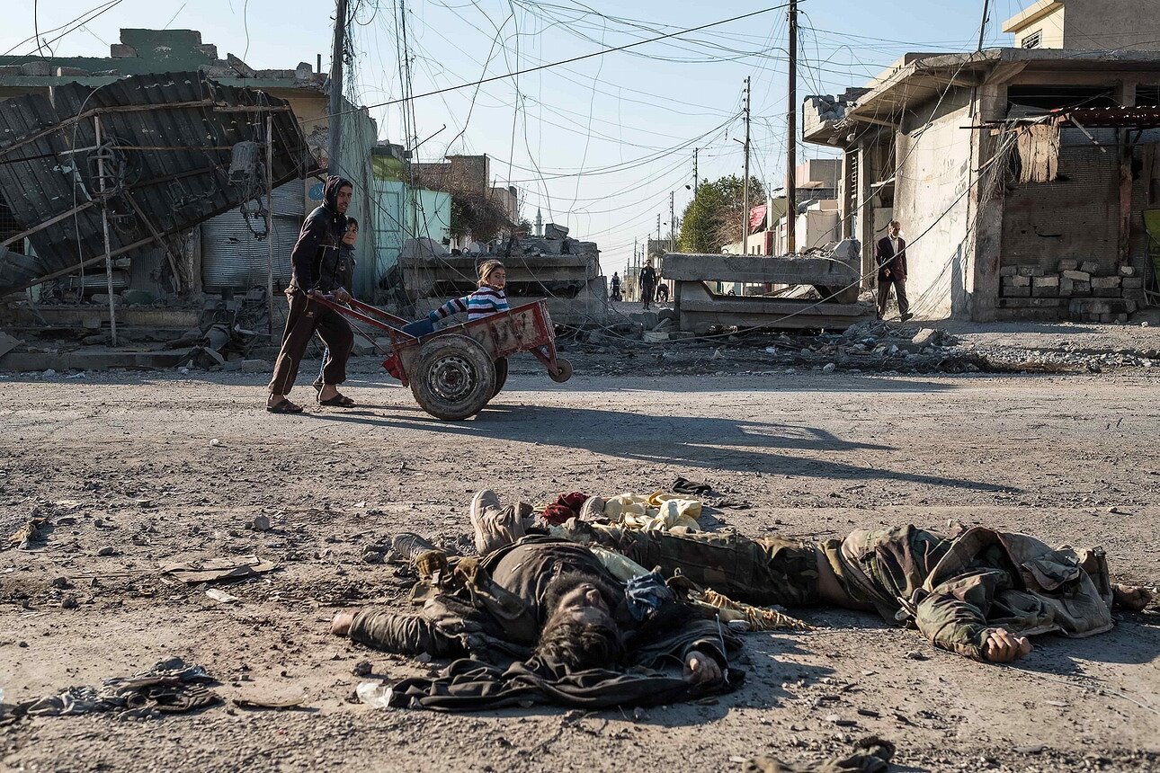 <p>Мирные жители возвращаются в освобожденный от ИГИЛ район Аль-Кудс. На пути &mdash; тела игиловцев, убитых в боях за район накануне.</p>