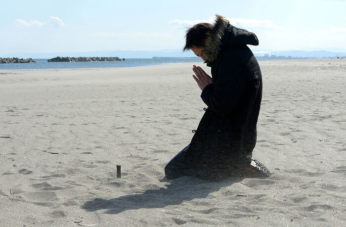Житель города Сендай молится о погибших во время цунами в Японии,  унесшем почти 19 тысяч жизней, Сендай, 11 марта 2013. Источник: AFP PHOTO / Toru Yamanaka