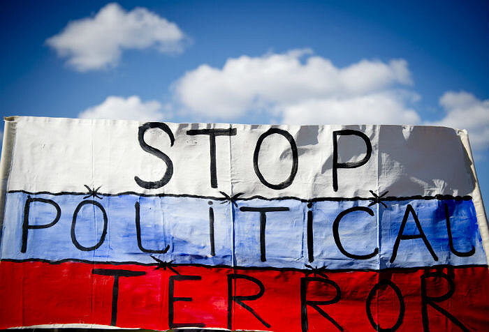 Надпись на флаге: «Остановим политический террор», Ганновер, 7 апреля 2013. Источник: AFP PHOTO / ODD ANDERSEN