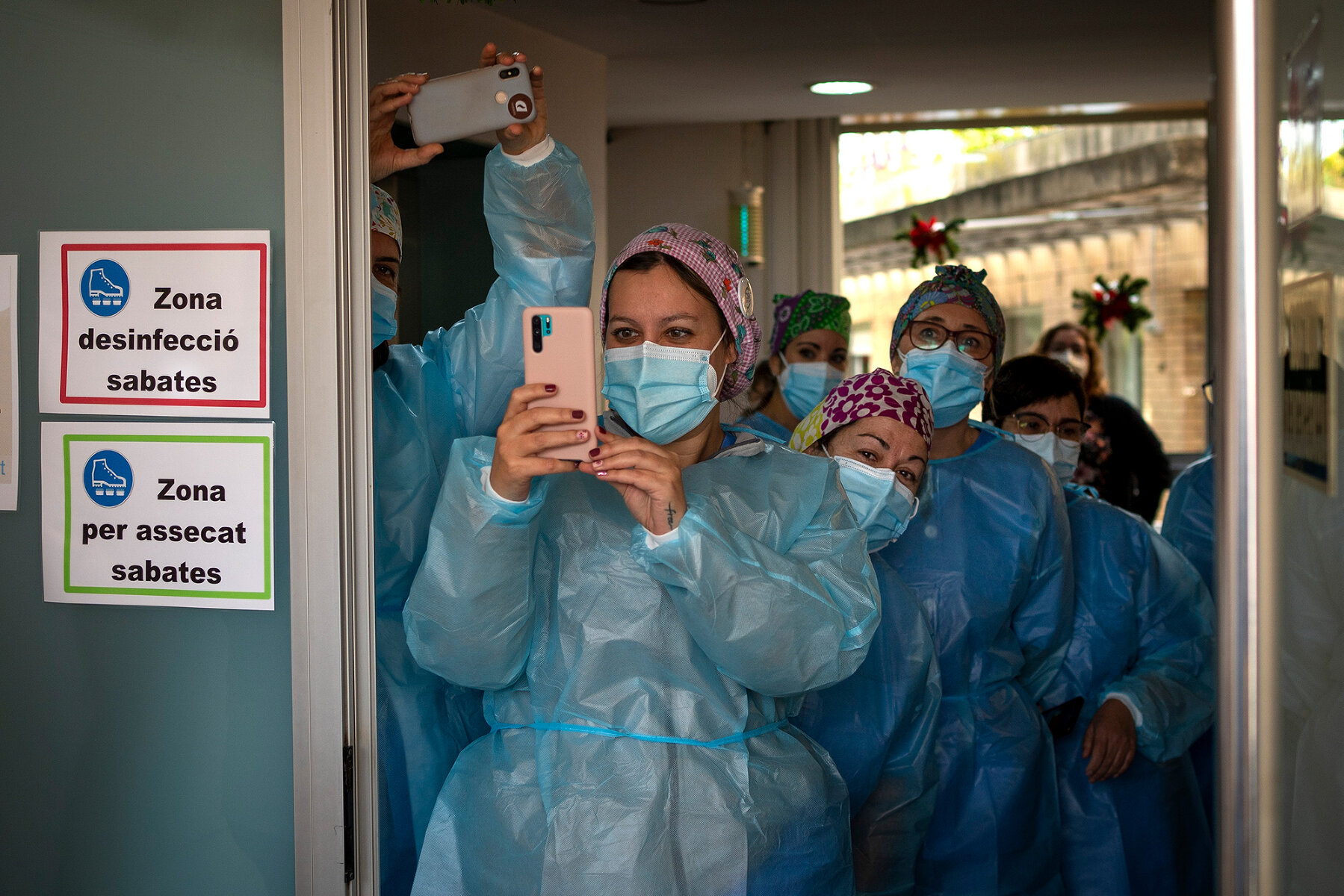 <p>Врачи и медсестры в одной из больниц Барселоны смотрят, как в учреждение завозят вакцину от коронавируса BioNTech-Pfizer, 27 декабря</p>