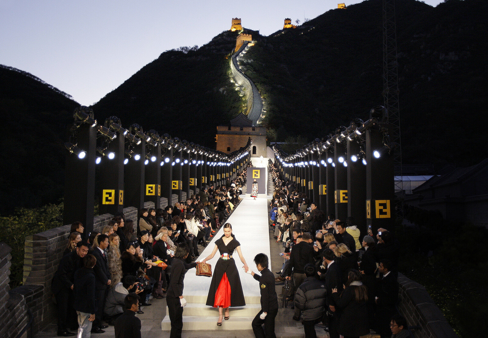 <p>Модели помогают сойти с подиума во время показа&nbsp;Fendi, организованного Лагерфельдом, на Великой китайской стене в 2007 году.</p>