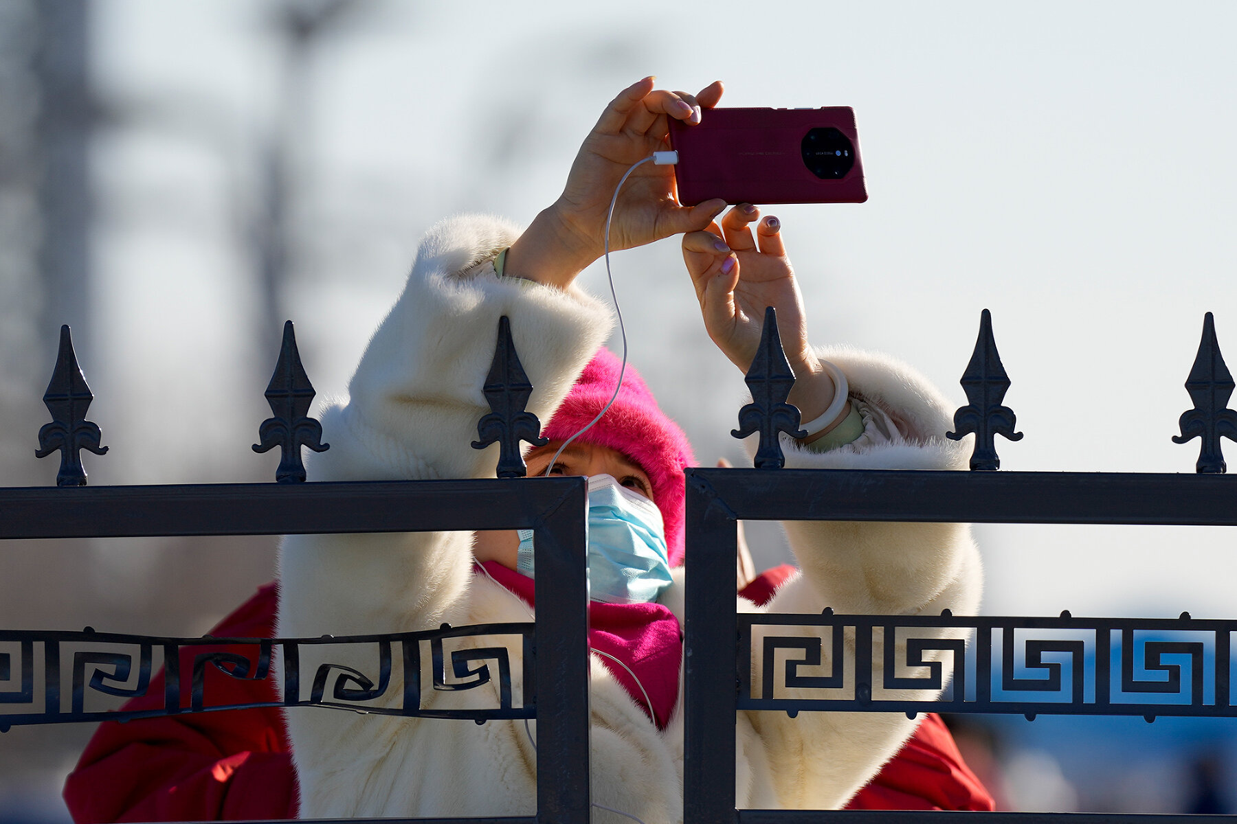<p>Женщина фотографирует через забор у границы &laquo;пузыря&raquo; в Пекине, 1 февраля 2022 года.</p>