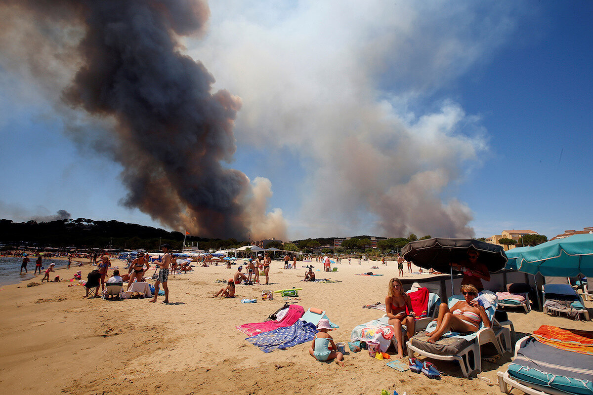 <p><strong>26 июля. Борм-ле-Мимоза, Франция</strong></p>

<p>Туристы отдыхают на пляже, пока дым заполняет небо над горящим холмом.</p>