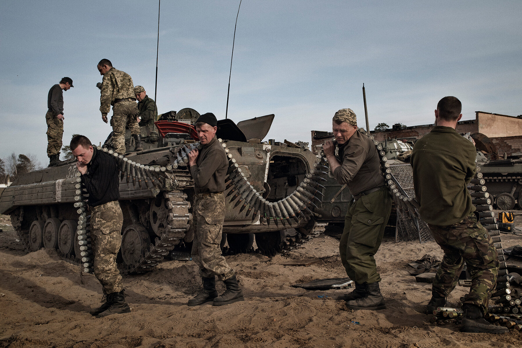<p>Военнослужащие загружают боеприпасы в старый БТР в тренировочном лагере недалеко от Днепропетровска, Украина. 26 марта 2015 года.&nbsp;</p>