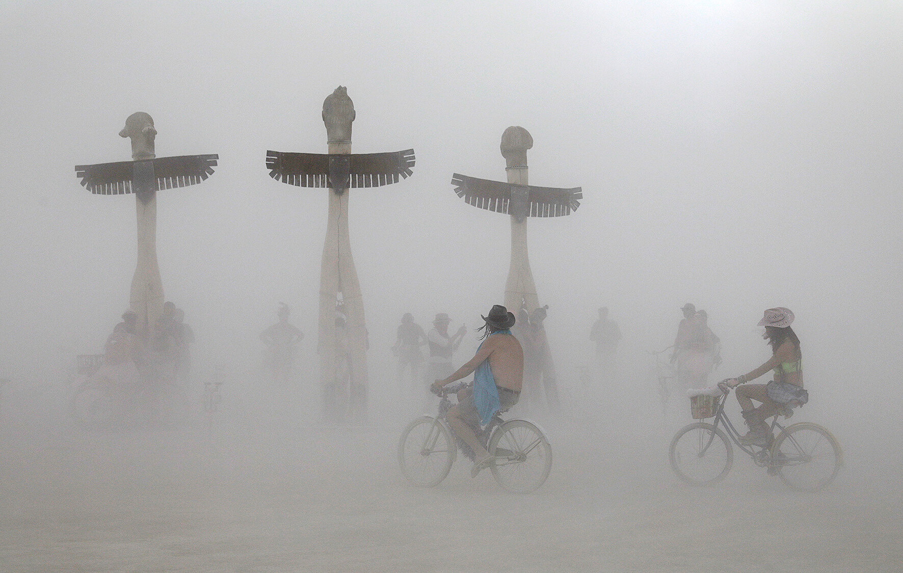 <p>Участники фестиваля на велосипедах проезжают мимо арт-проекта Джеймса Тайлера &laquo;Буревестники&raquo;&nbsp;во время песчаной бури</p>