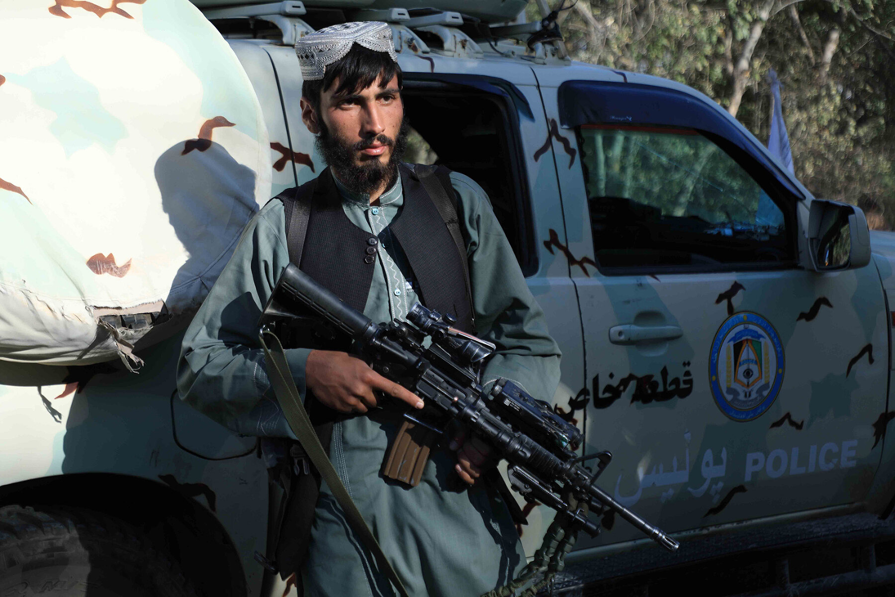<p>Боевик на фоне захваченного у сил безопасности Афганистана автомобиля в провинции Герат, 15 августа 2021 года</p>