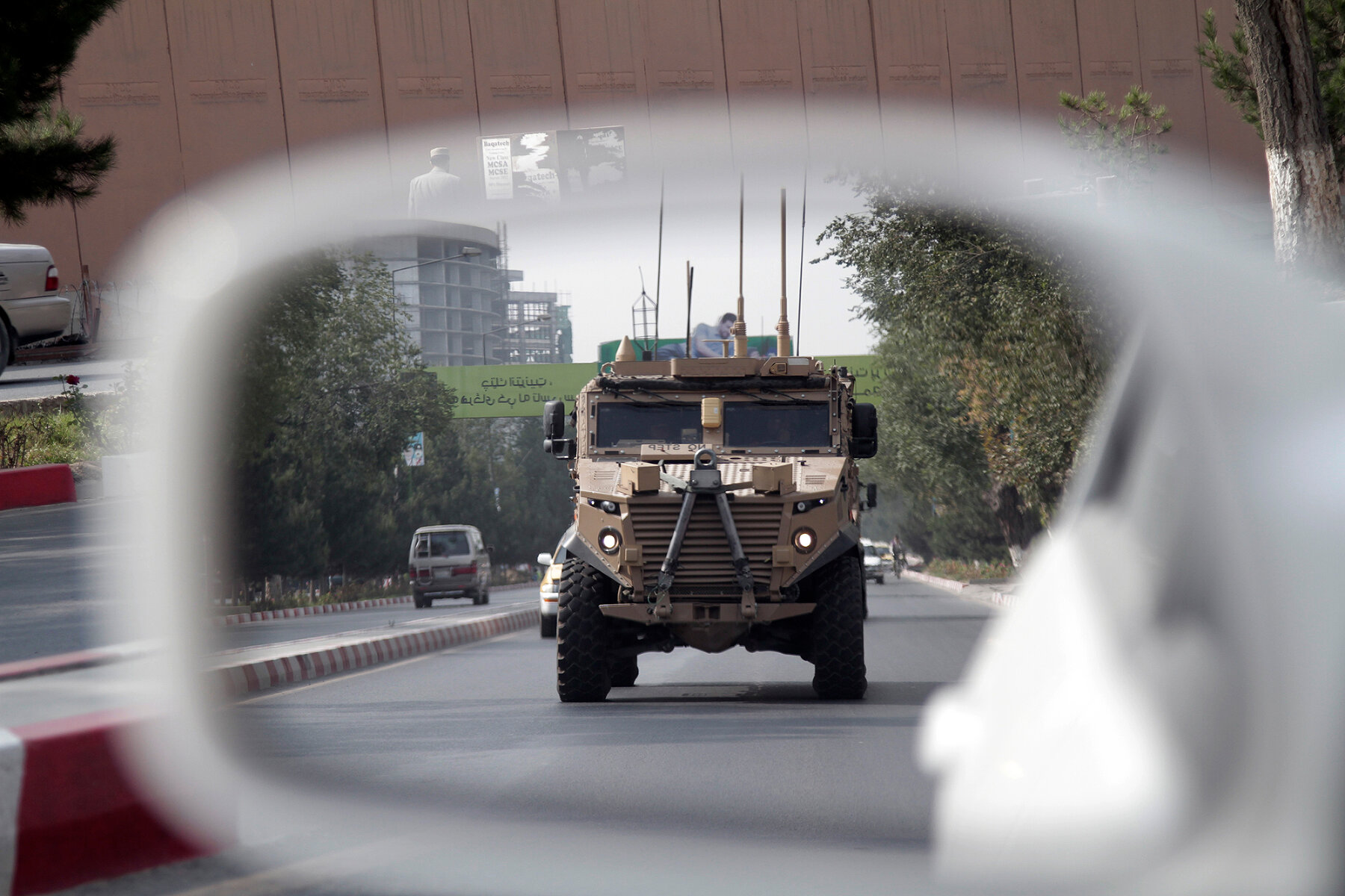 <p>Патрульная машина армии США в центре Кабула отражается в зеркале заднего вида гражданского автомобиля, 23 августа 2017 года</p>