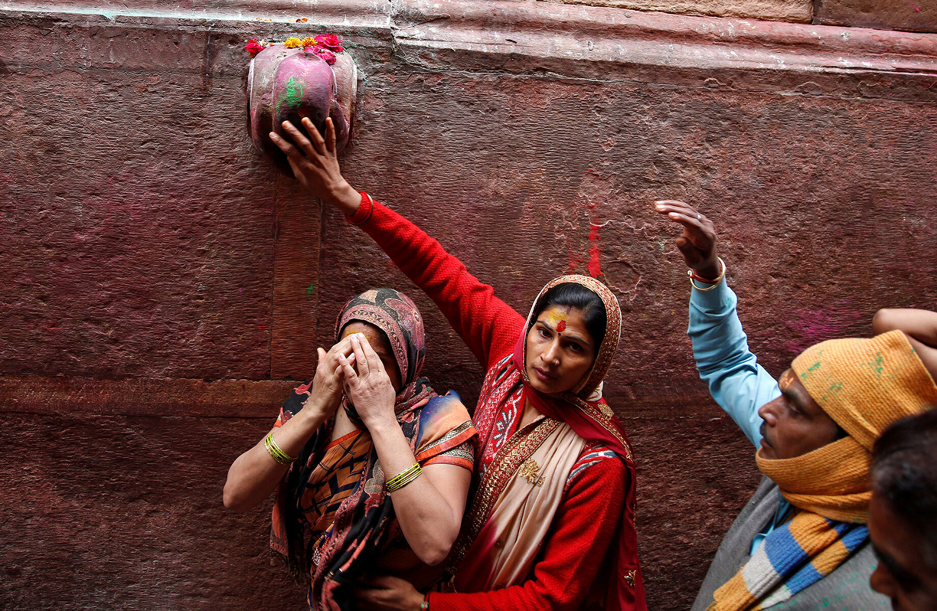 <p>Религиозные индусы прикасаются к камню вне храма, как бы принимая участие в фестивале Холи в Вриндаване.</p>