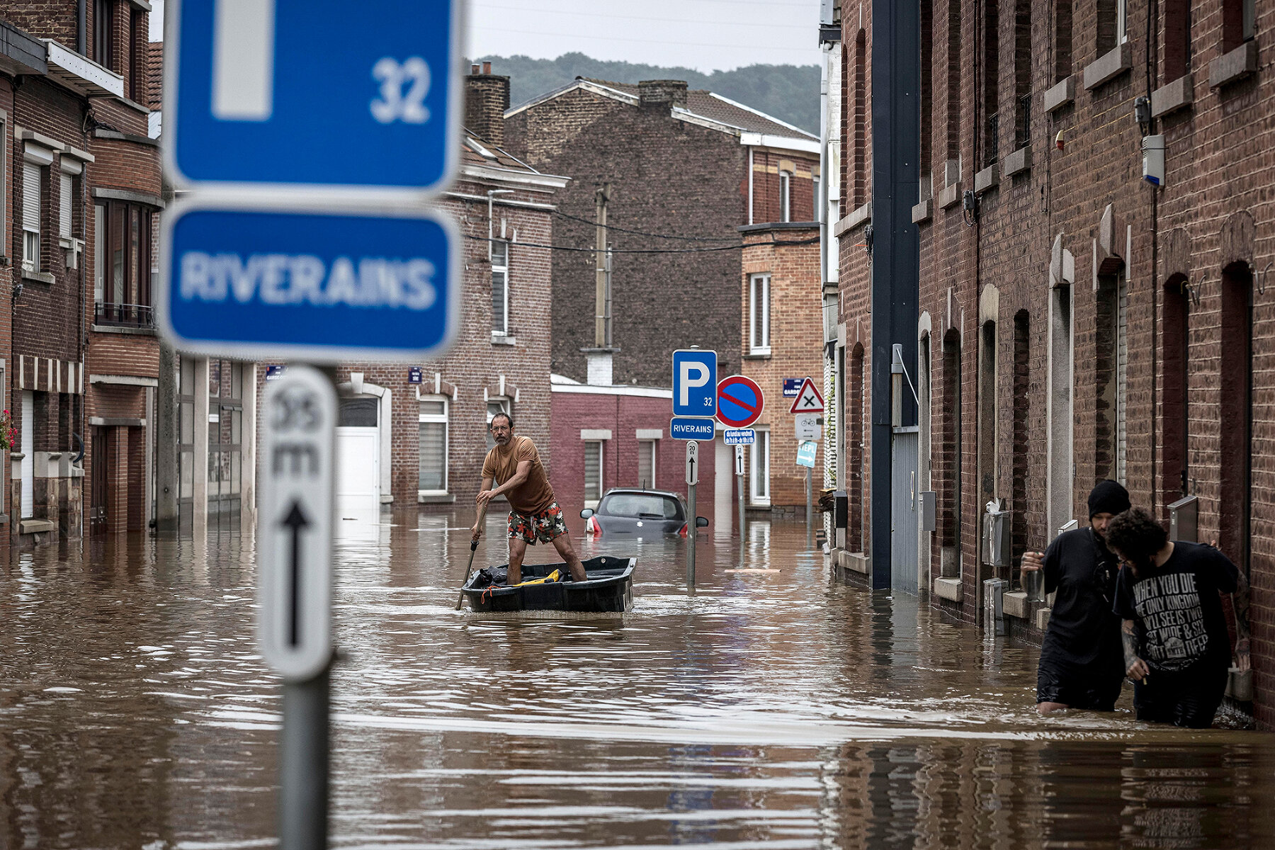 <p>Мужчина плывет на лодке по затопленной улице в Льеже, Бельгия</p>