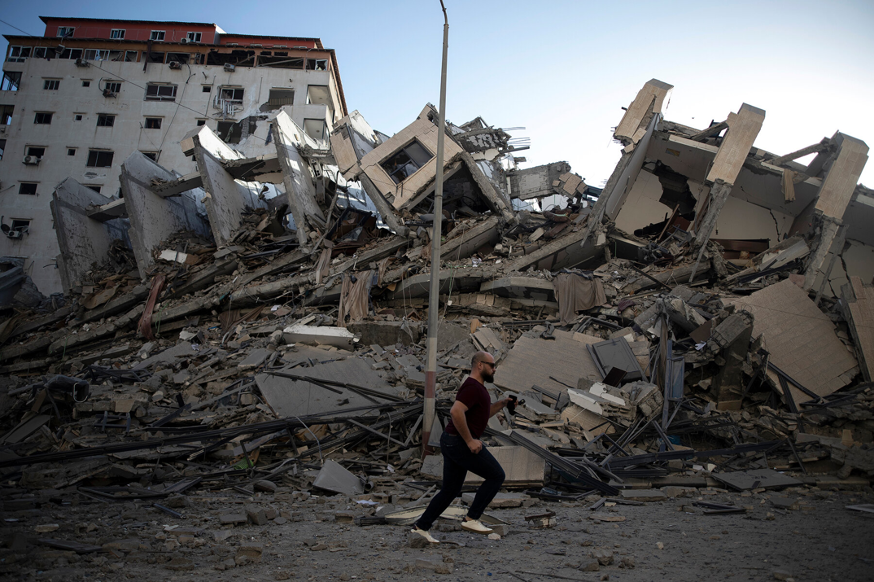 <p>Палестинец проходит мимо развалин дома, уничтоженного ответным ударом Израиля</p>
