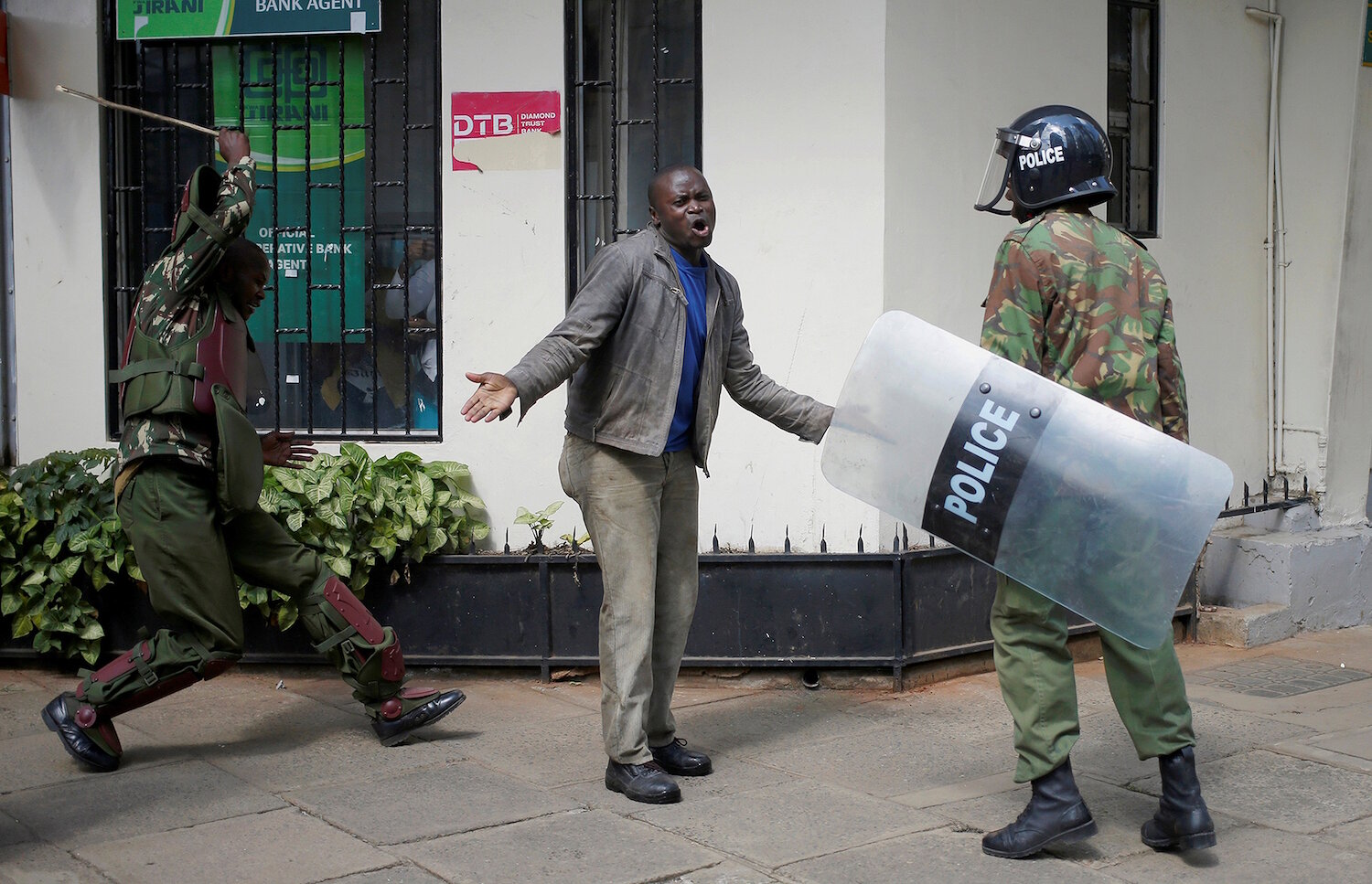 <p>16 мая. Найроби, Кения. Полицейский бьет демонстранта во время акции протеста.</p>