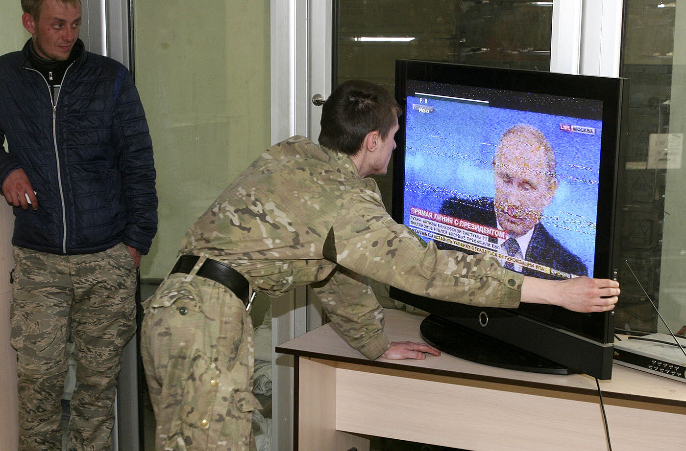 <p>Украина, Донецкая область, 2015 год. Представители самопровозглашенной Донецкой народной республики настраивают телевизор во время трансляции</p>