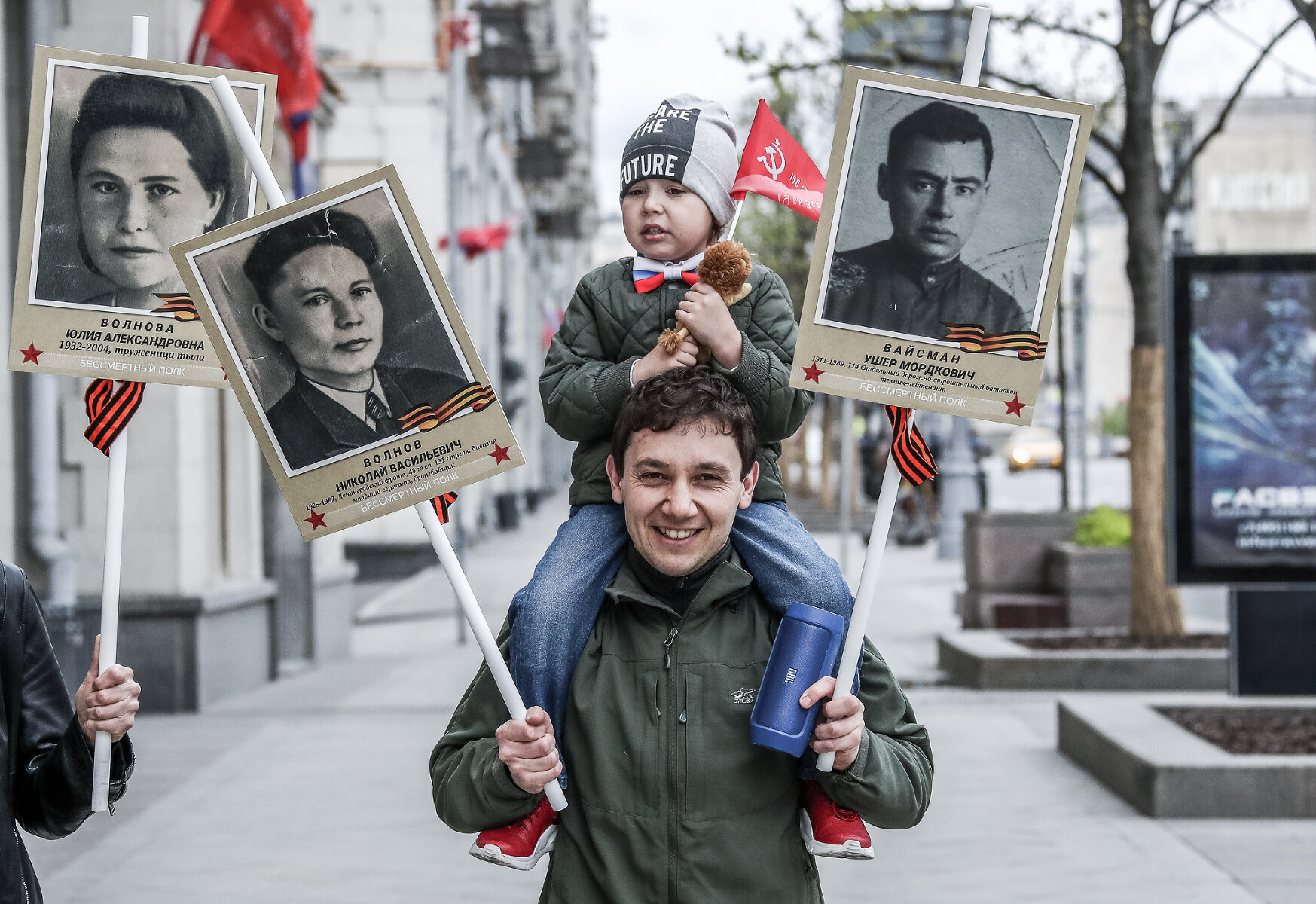 <p>Москва. Мужчина с ребенком идут по Тверской улице с портретами родственников, участвовавших в Великой Отечественной войне</p>