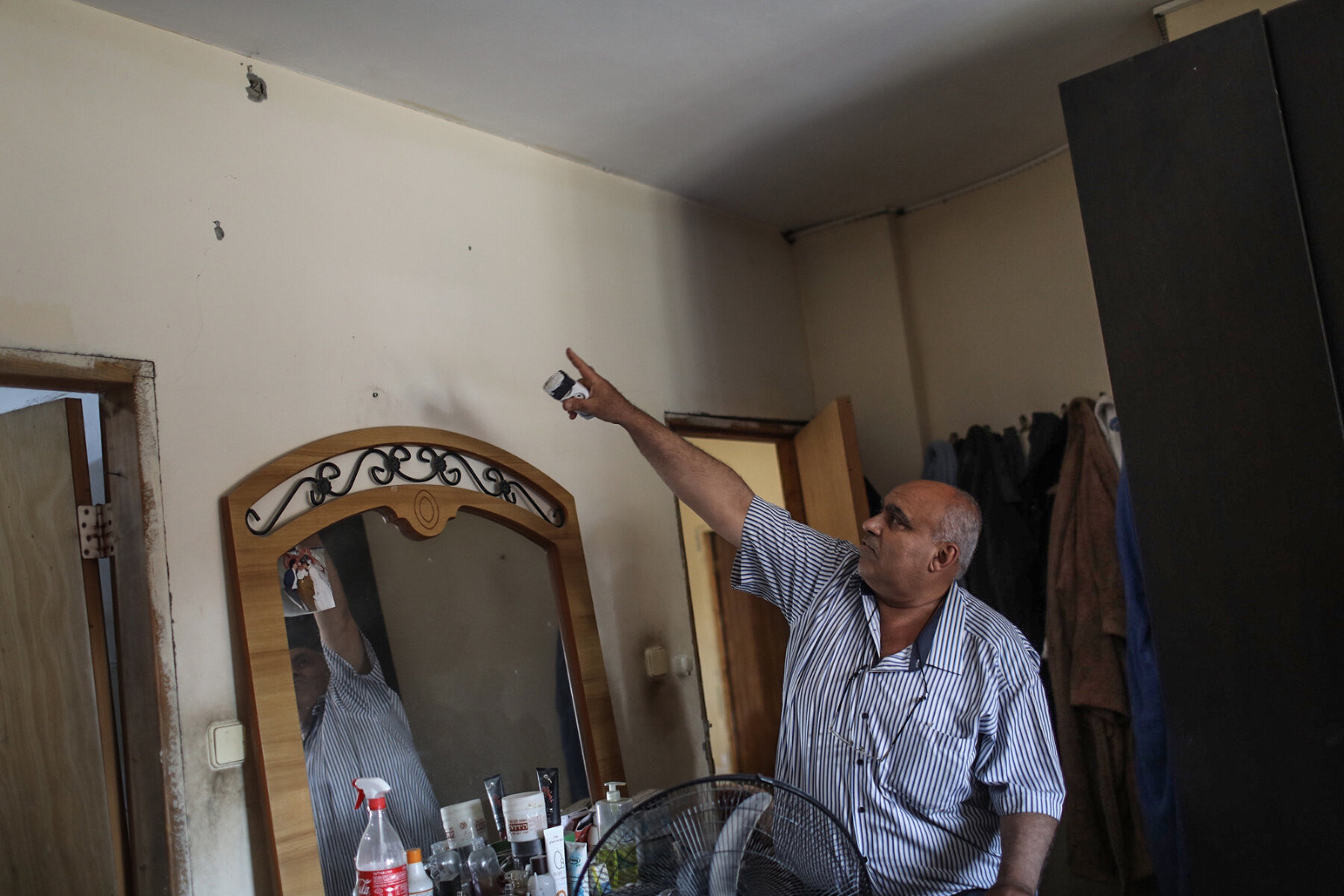 <p>Житель Лода показывает повреждения в доме после ракетного удара</p>